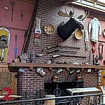 Re-creation of Frederic Remington's studio, displaying an array of his personal items, artwork tools, and Western memorabilia against a rustic backdrop.