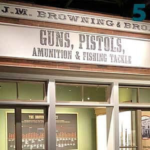 Recreation of John Moses Browning's workshop displaying a historic storefront with signage for guns, pistols, ammunition, and fishing tackle.