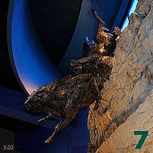 Dynamic sculpture 'Free Fall' by T.D. Kelsey, 2002, depicting animals in motion, mounted dramatically on a rocky precipice.