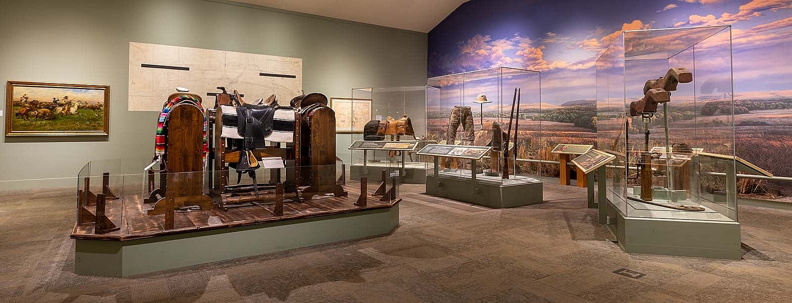 Buffalo Bill Museum, view of artwork on the wall, saddle display, frontier accoutrements.,