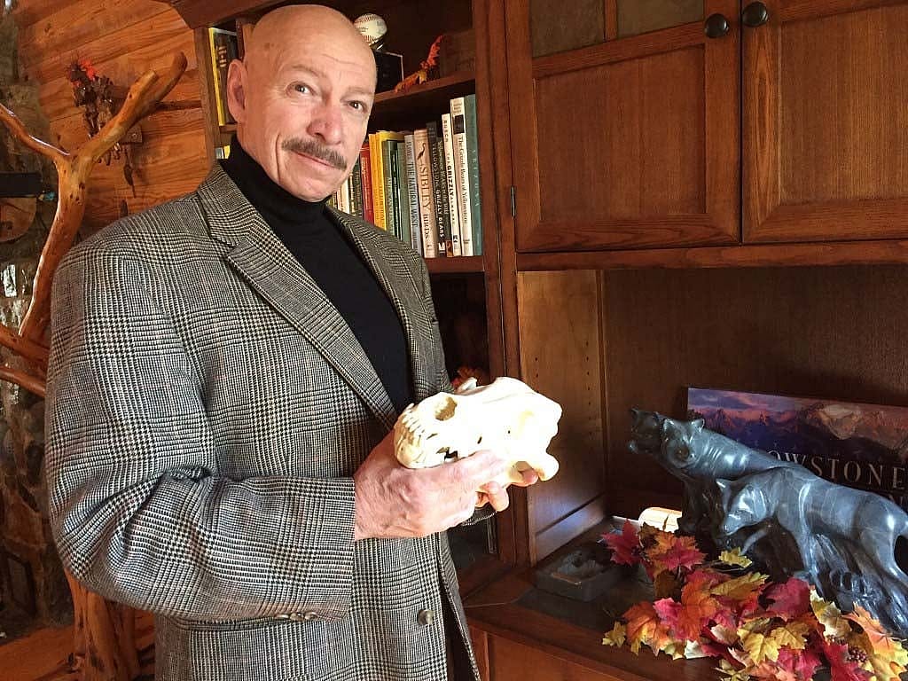 Dr. Charles Preston shown in a study holding an animal skull.