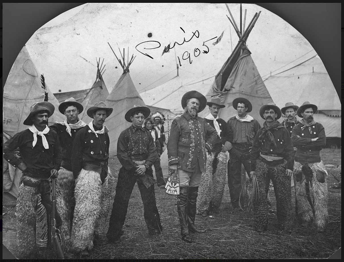 William F. "Buffalo Bill" Cody with Wild West cowboys in front of tipis.