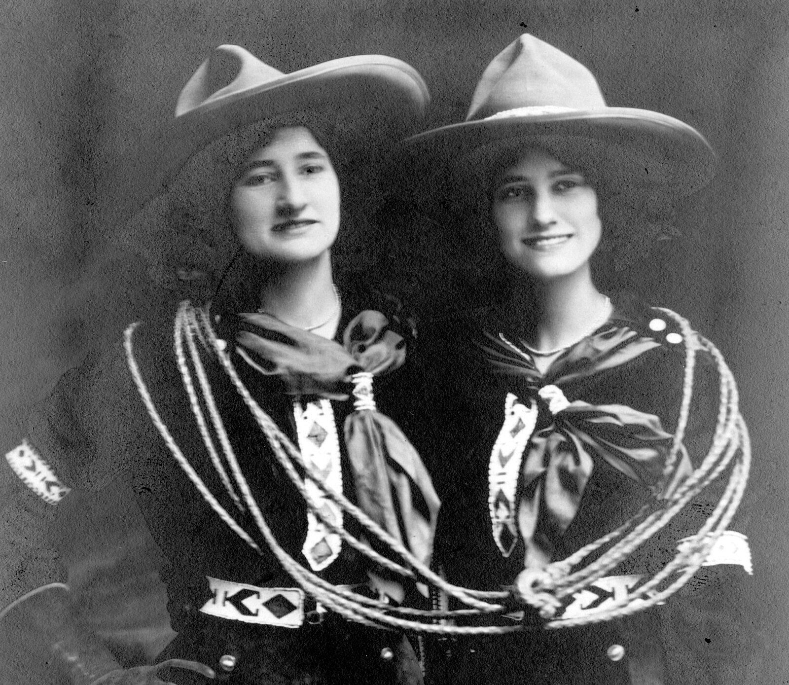 Black and white photograph of two women Wild West performers with show costumes and large hats.