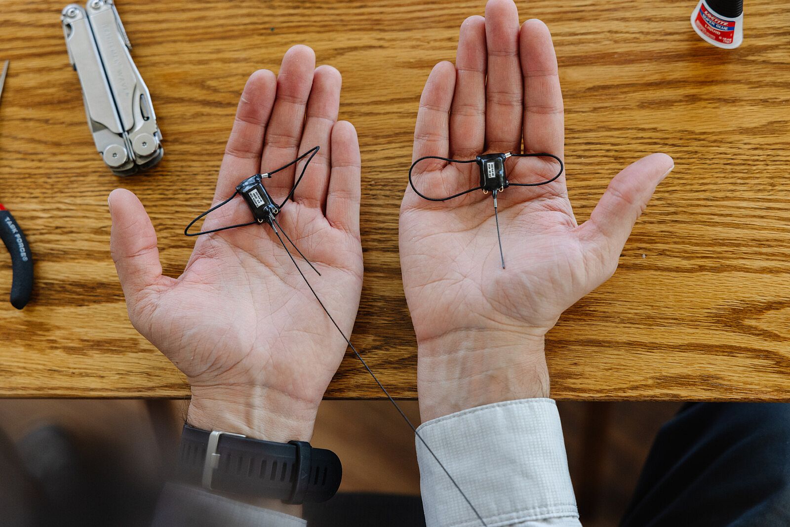 GPS backpacks displayed in a researcher's palms showing the relative size of an Argos device and a Store-on-Board device.