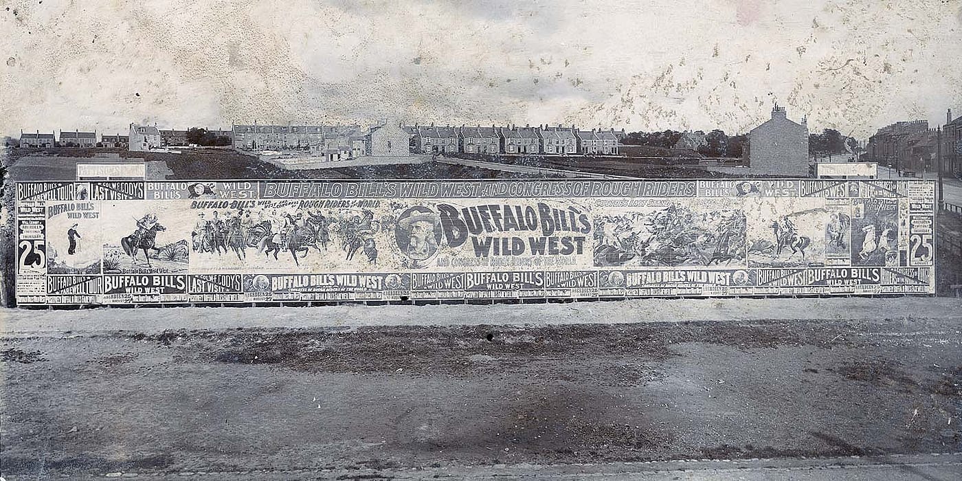 Posters for Buffalo Bill's Wild West cover a large billboard in Scotland, 1904. MS 392 Harrison H. Gunning Collection. P.392.009